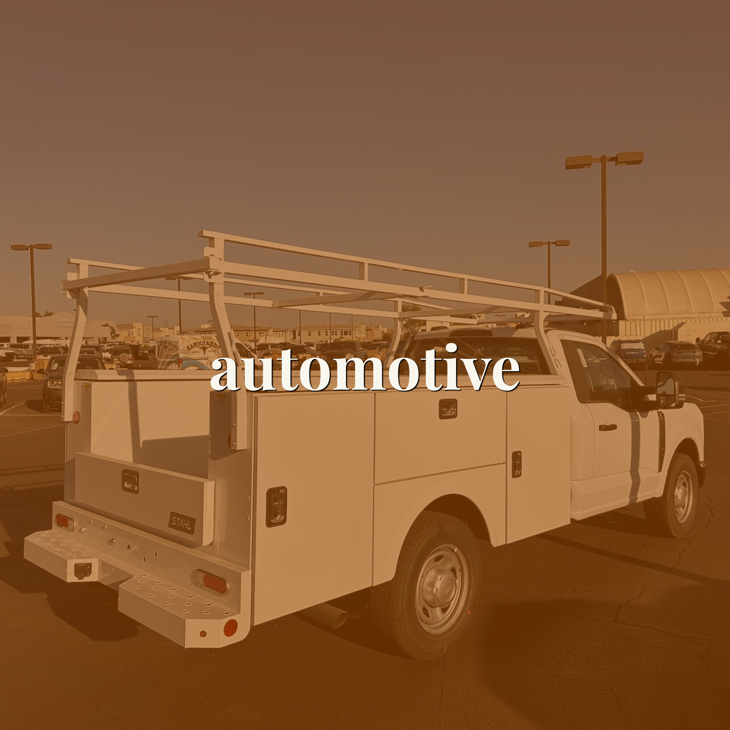 White service truck with a ladder rack in a parking lot — link to the automotive portfolio
